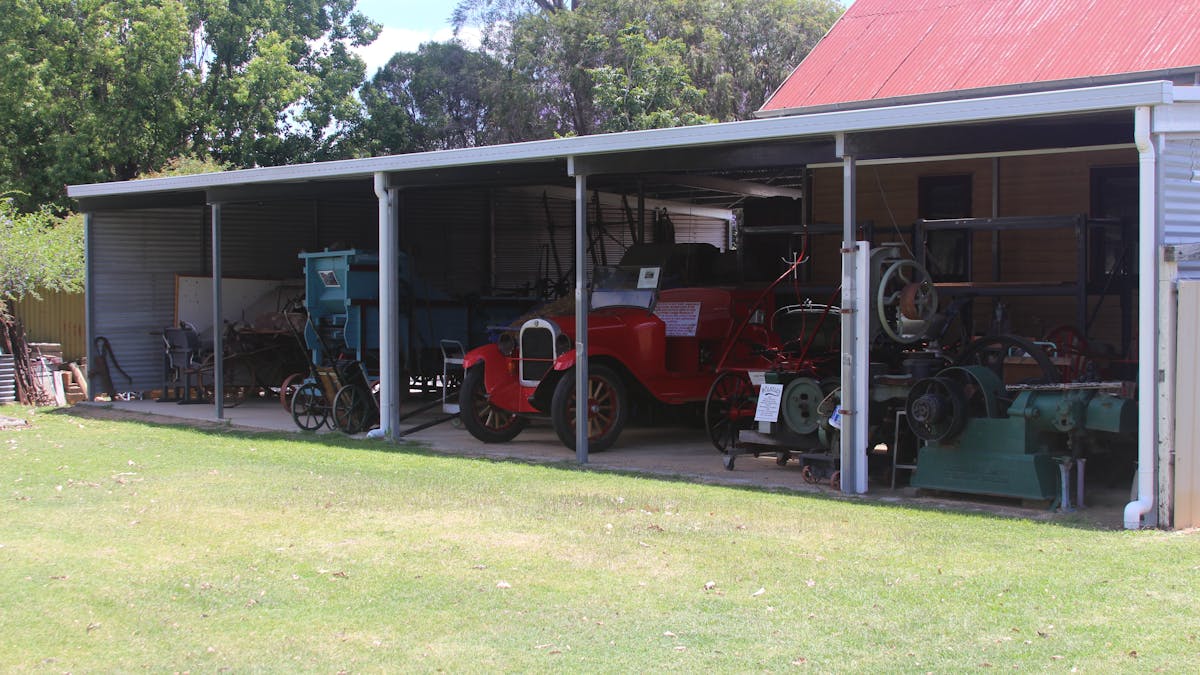 A shed containing a collection of historical farming machinery and an old fire engine.