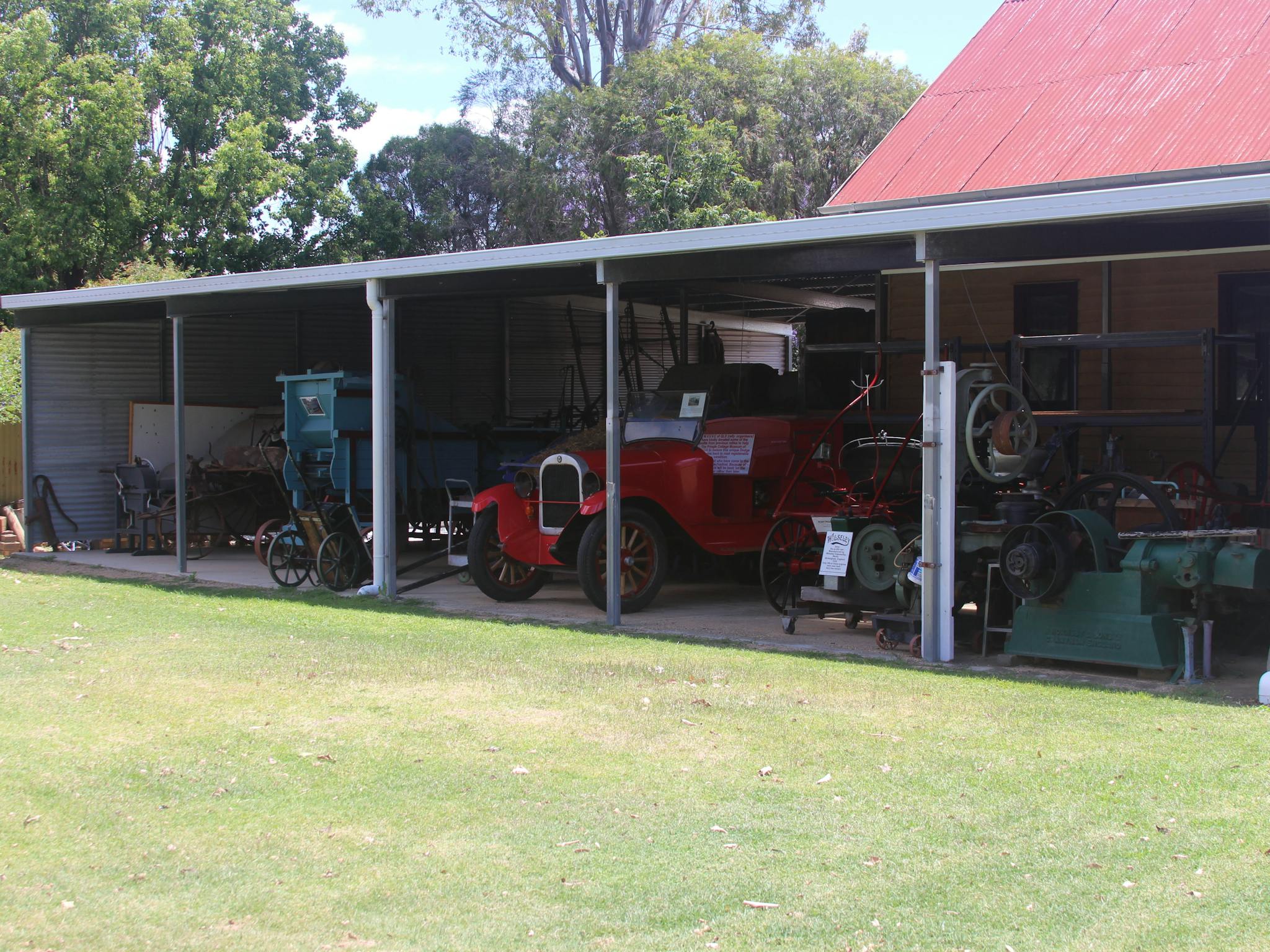A shed containing a collection of historical farming machinery and an old fire engine.