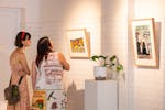 Two people looking at artwork in a gallery space.