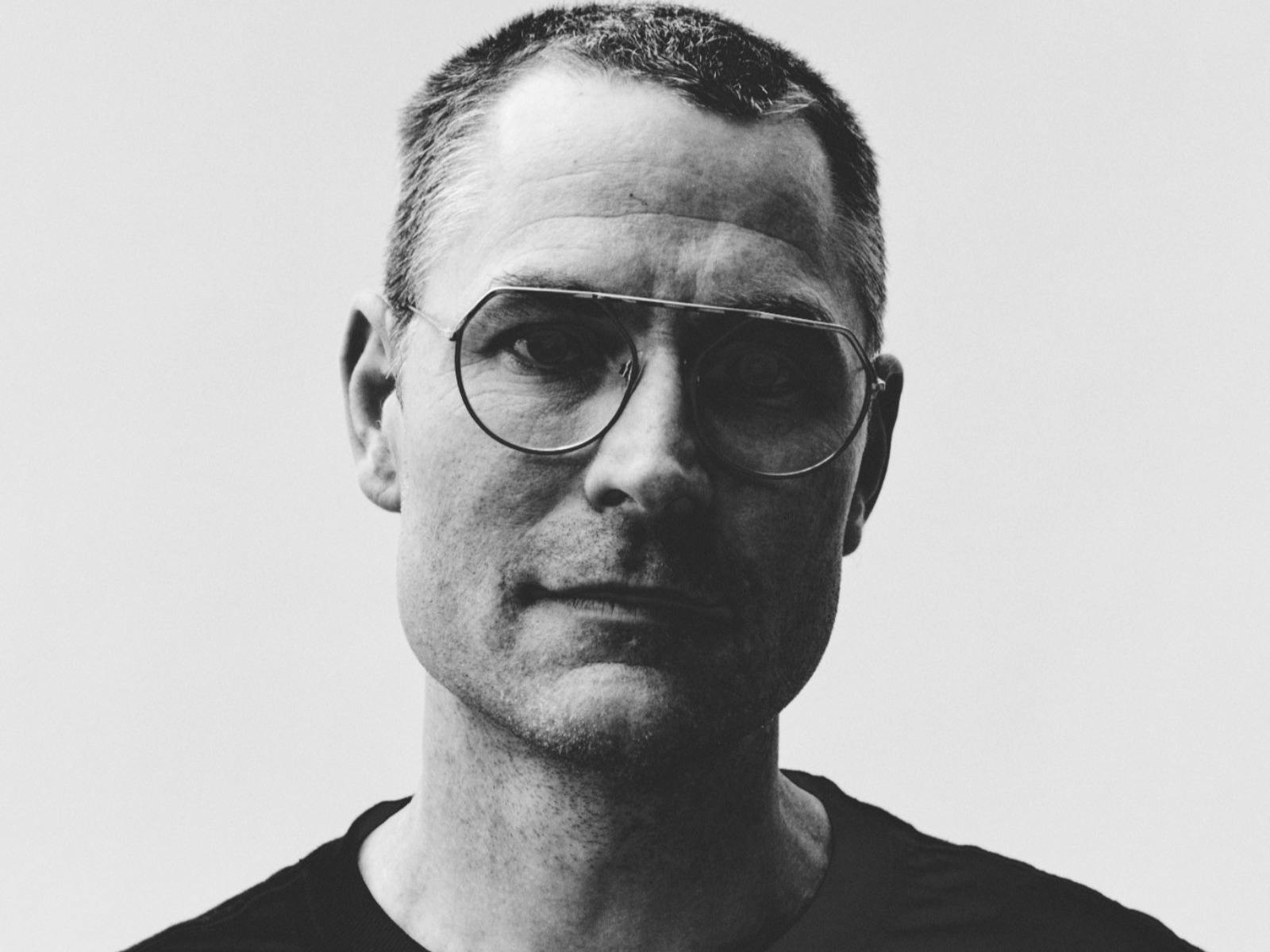Black and white image of man wearing glasses looking at camera