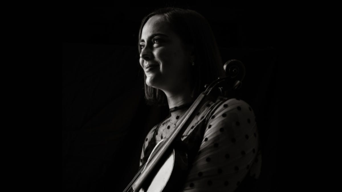 Black-and-white portrait of a violinist in profile, looking toward the light