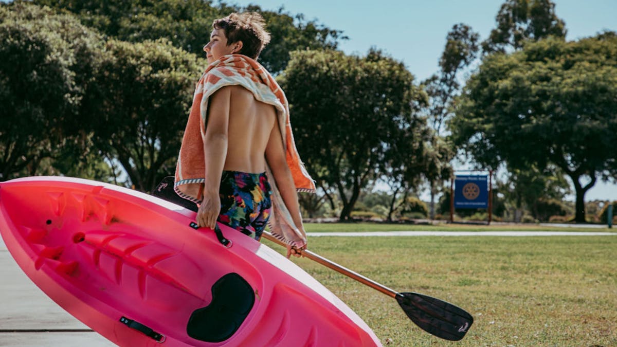 Young boy walking with a pink kayak at the Goondiwindi Water Park