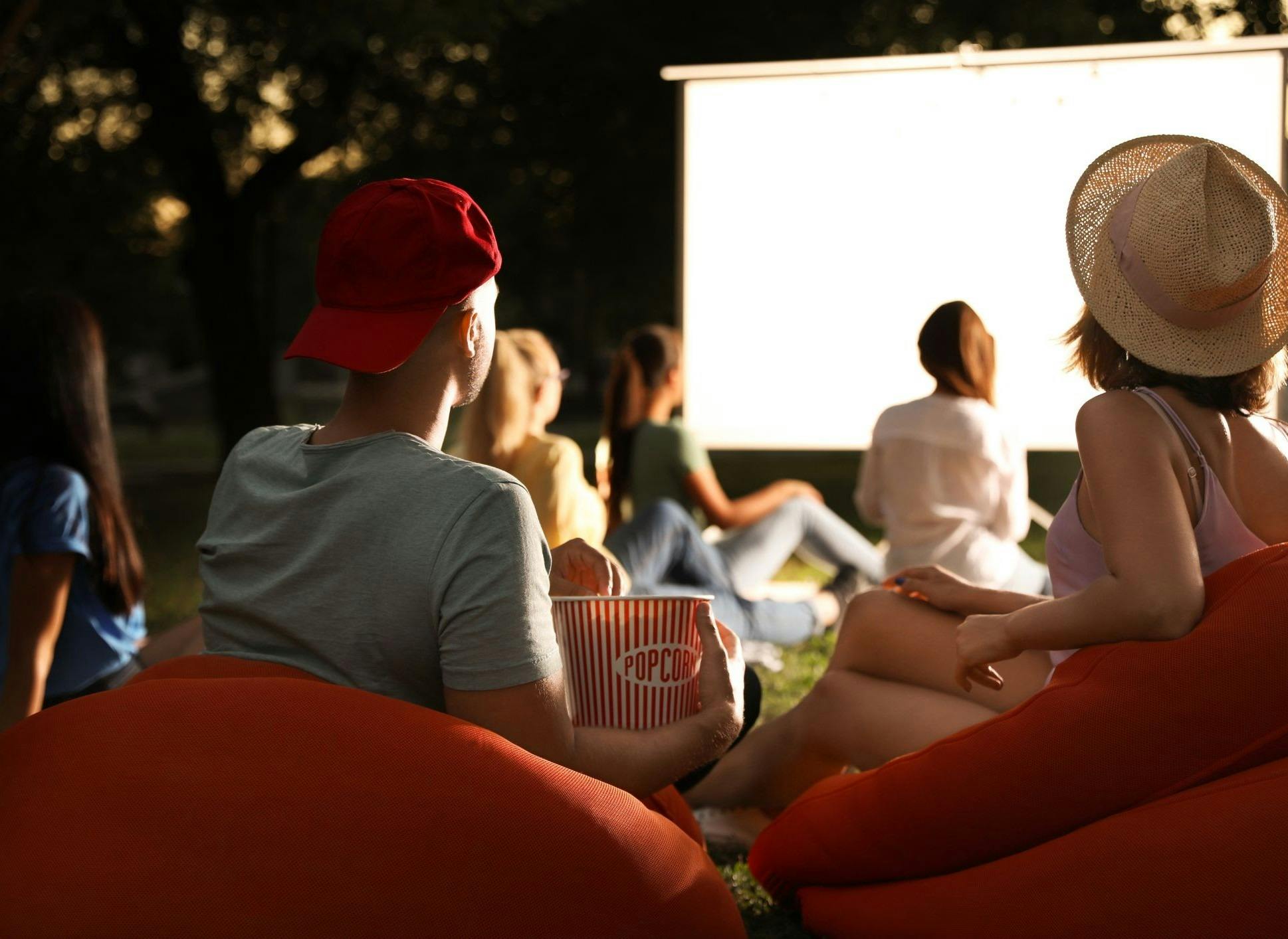 people sat on beanbags outside watching a cinema screen