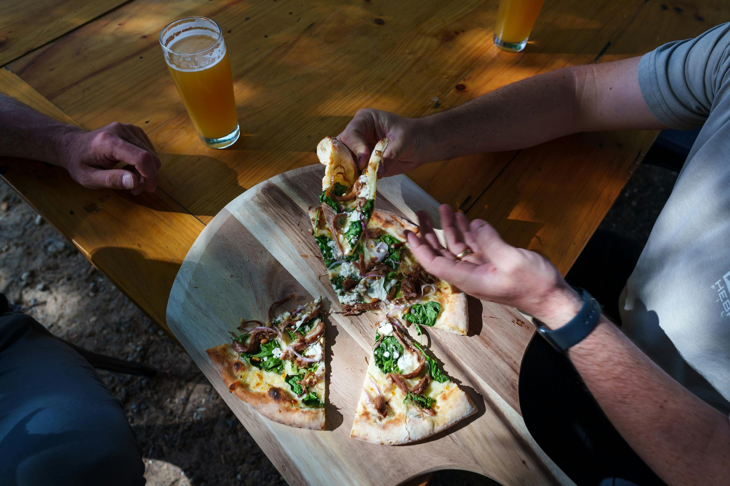Beer and pizza being enjoyed