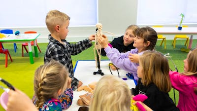 A group of children exploring a miniature skeleton
