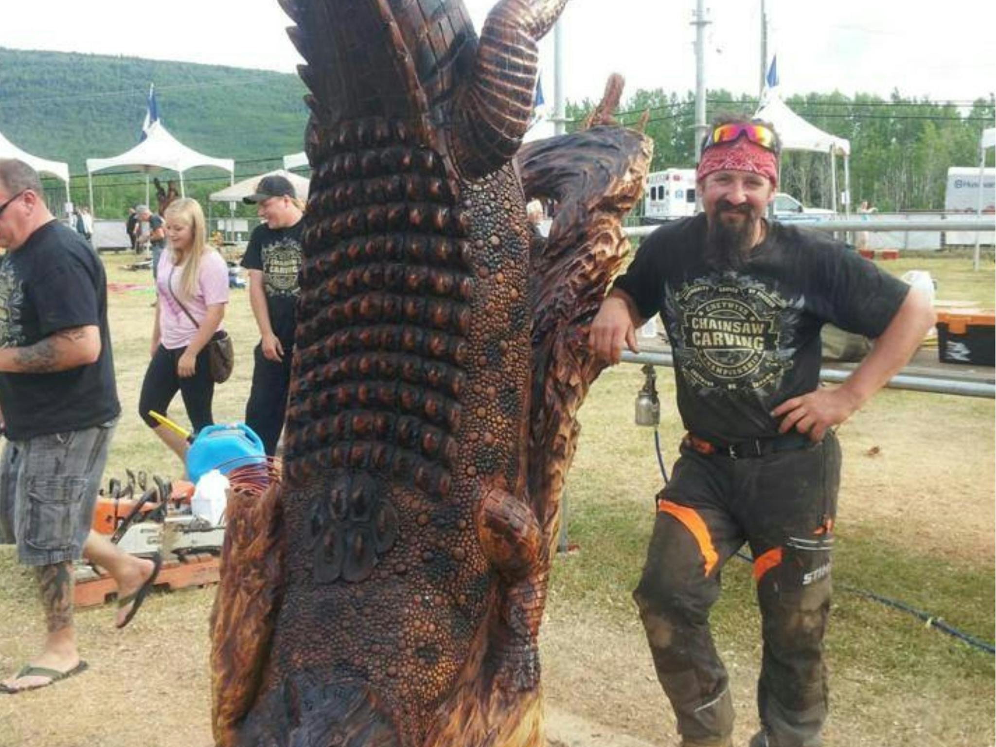 Carver standing next to his crocodile wood carving