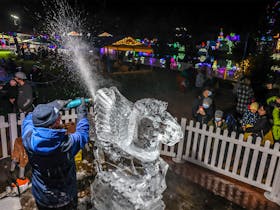 A man carving a pegasus into ice