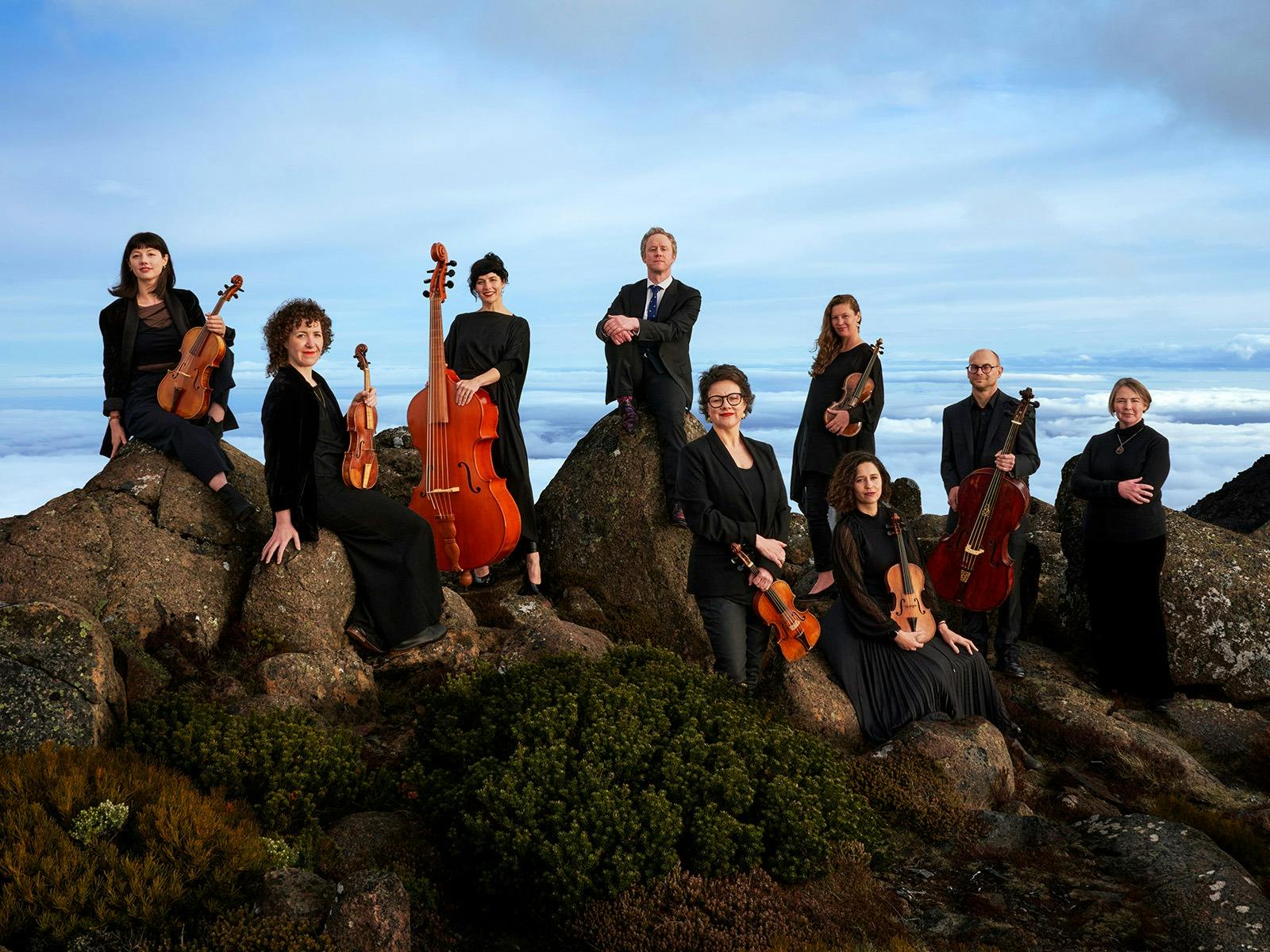 Van Diemen's Band perched on the Mountain rock s of kunyani, the sky stretches blue behind them