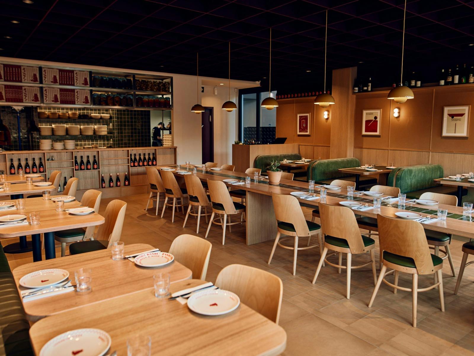 a dining room full of tables and chairs, with a low dark ceiling