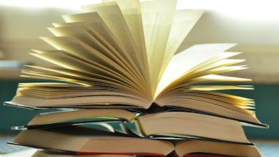 Open Books stacked up on a table