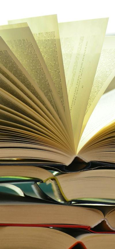 Open Books stacked up on a table
