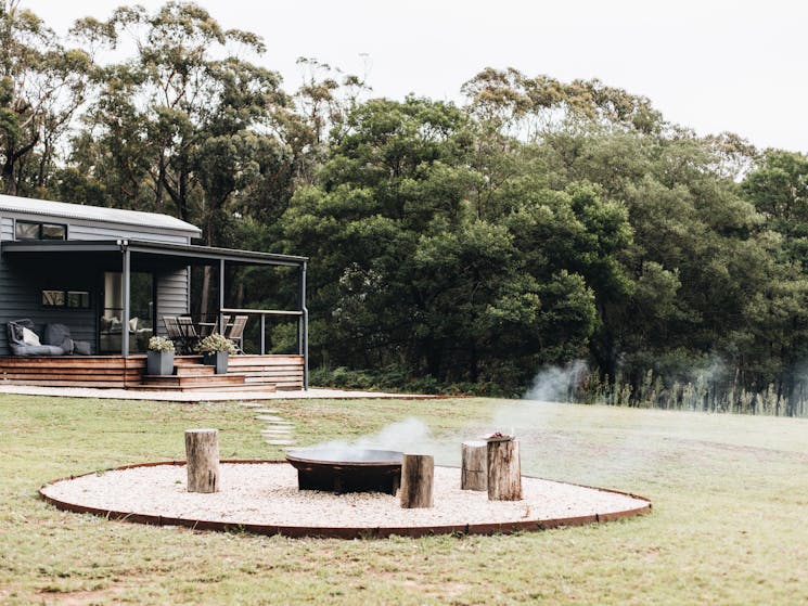 Rustic fire pit surrounded by logs for seating, just moments walk from your tiny house