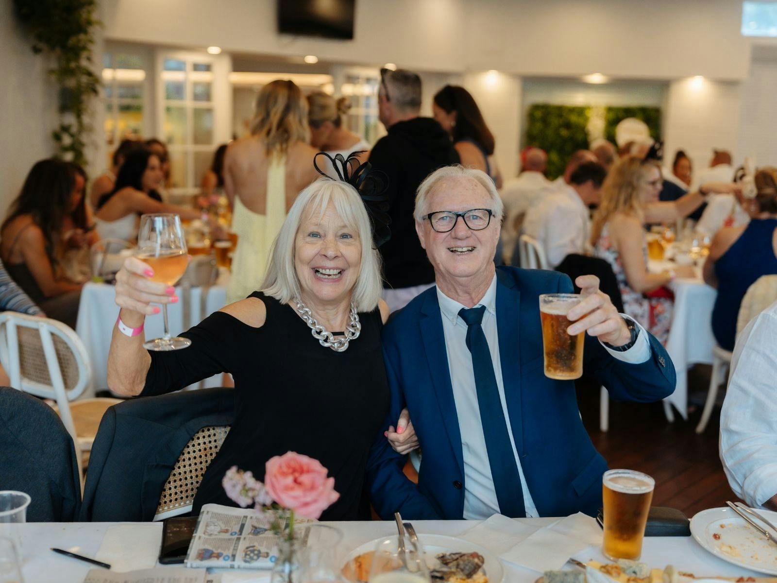 Couple raising their drinks during Melbourne Cup at Towradgi Beach Hotel.