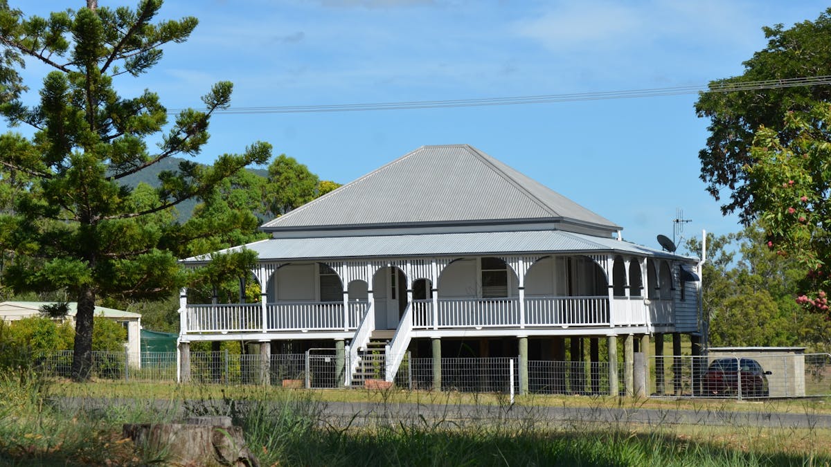 photo of an old Queensland style house  with front stairs leading to a verandah across the house