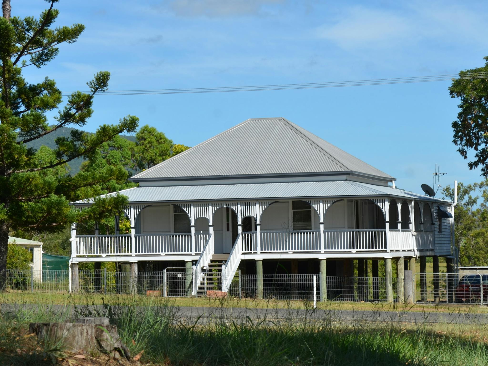 photo of an old Queensland style house with front stairs leading to a verandah across the house photo of an old Queensland style house with front stairs leading to a verandah across the house