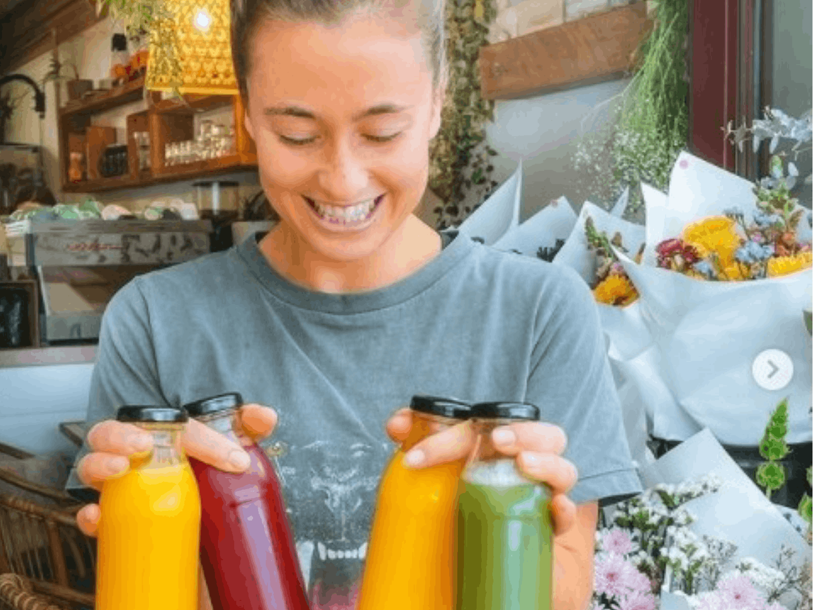 Lady holding 4 bottles of pressed juice