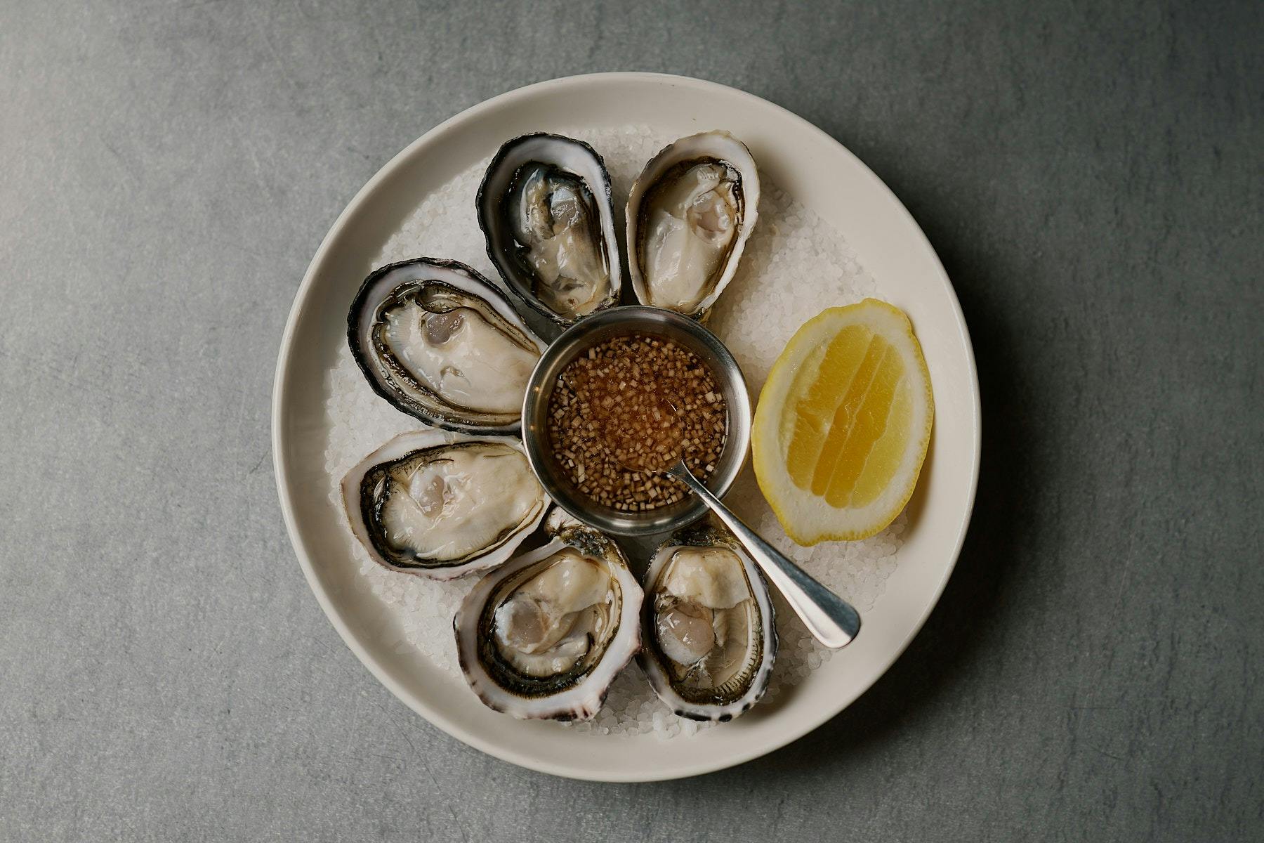 round white plate with shucked rock oysters