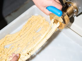 Fresh pasta being hand cut off the machine