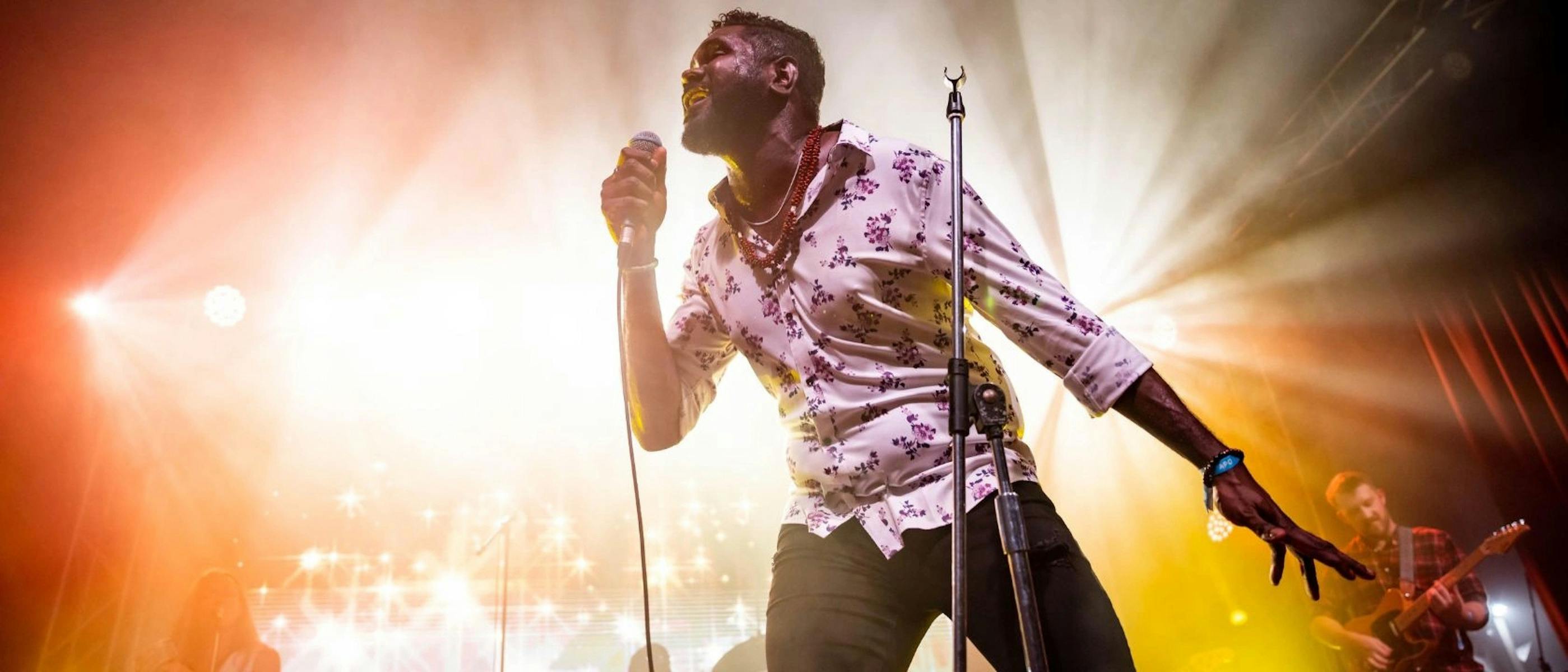 A man singing on a stage with a microphone