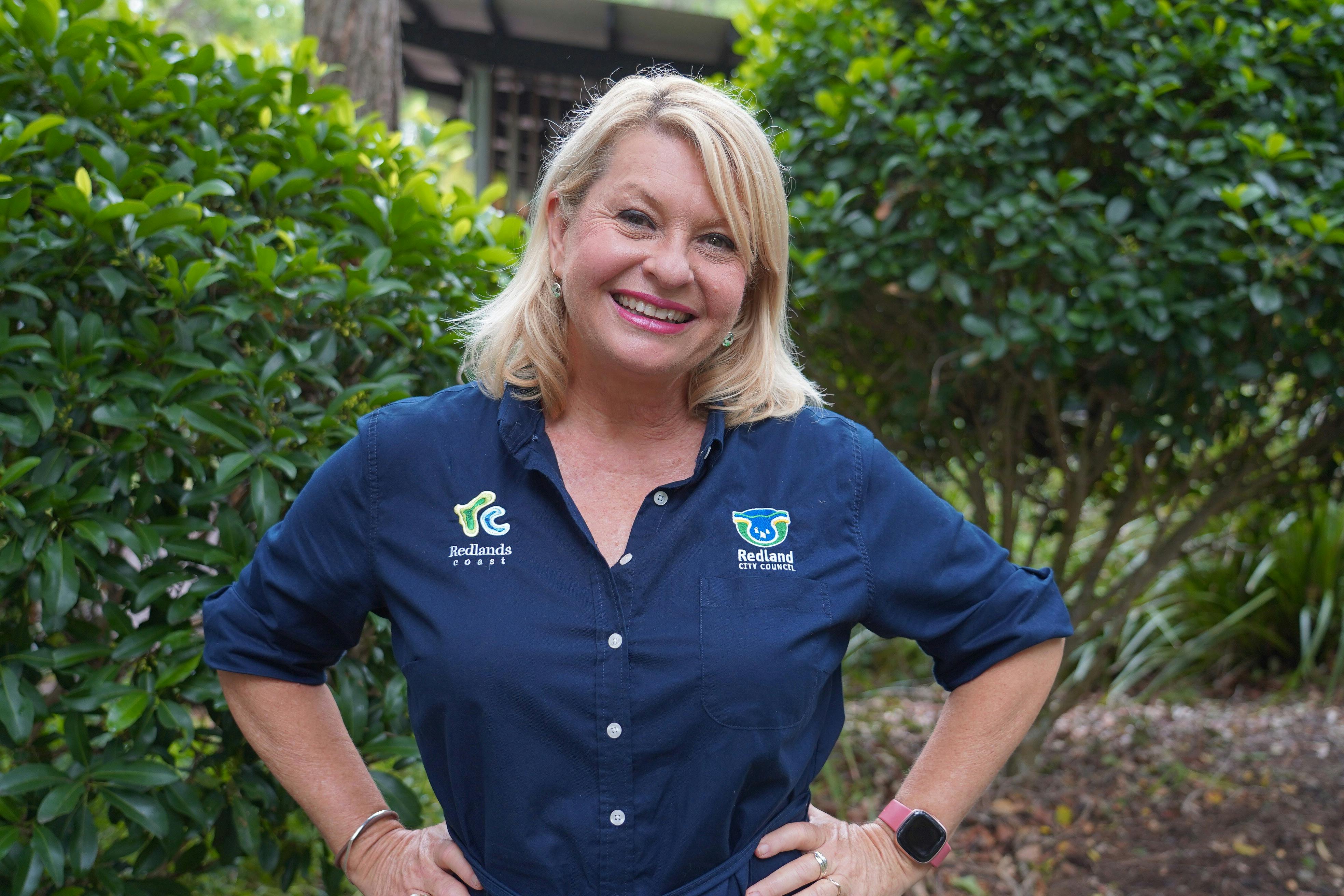 Ranger Stacey in uniform standing with hands on hips in the gardens at IndigiScapes