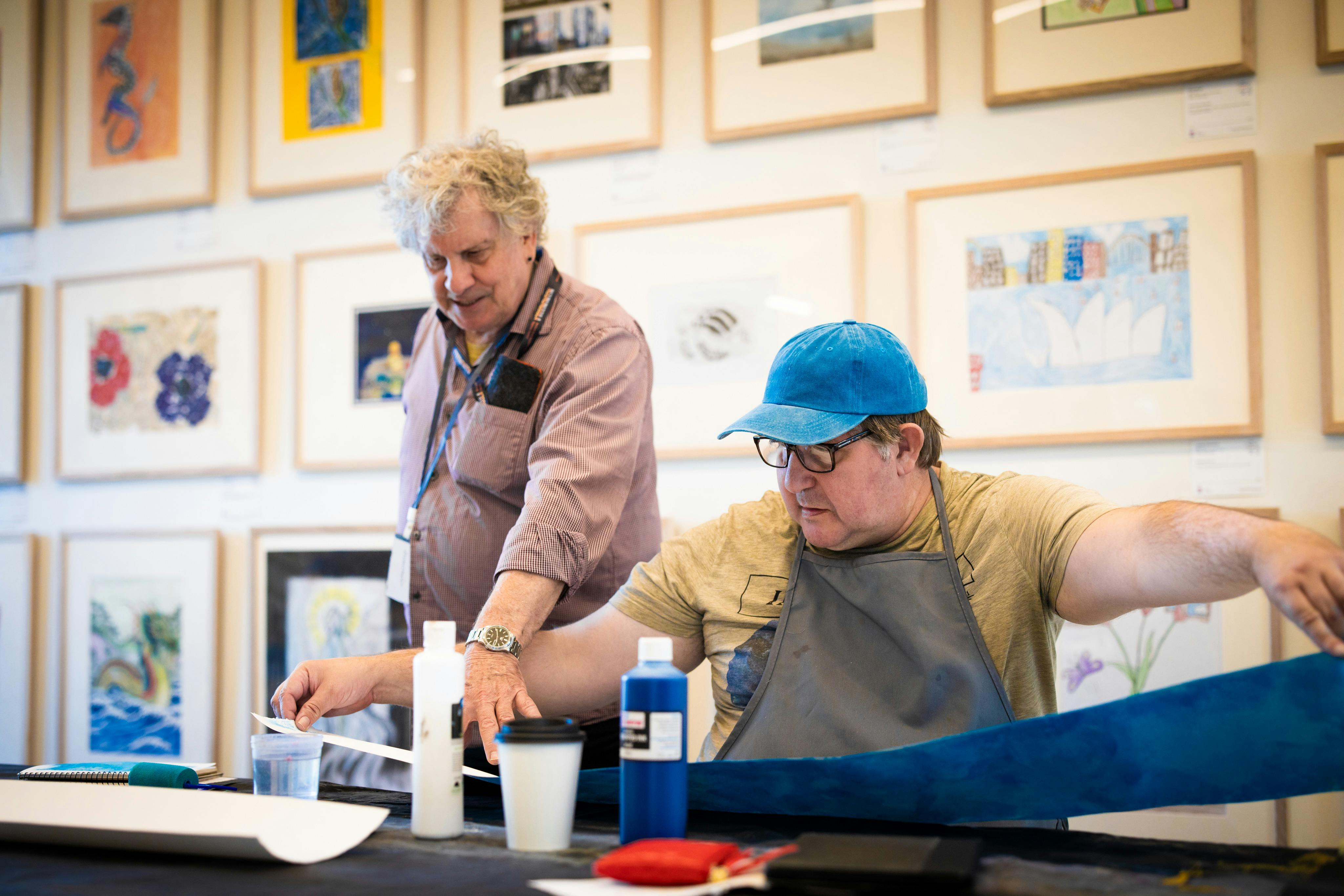 Two men in a gallery Art Space. One is pointing to something on a desk