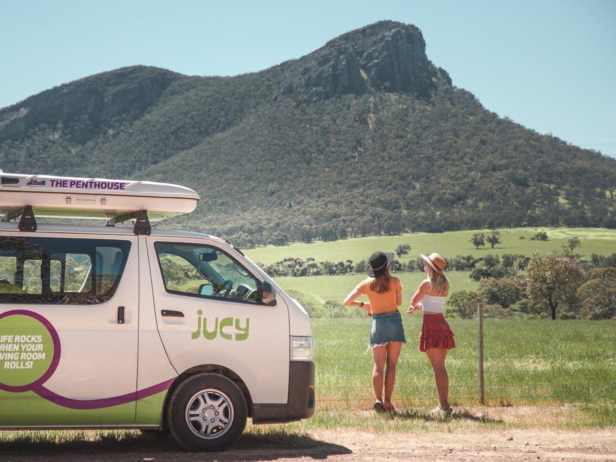 Two girls and campervan overlooking mountain
