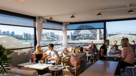 People enjoying food and drink at Henry Deane's rooftop cocktail lounge