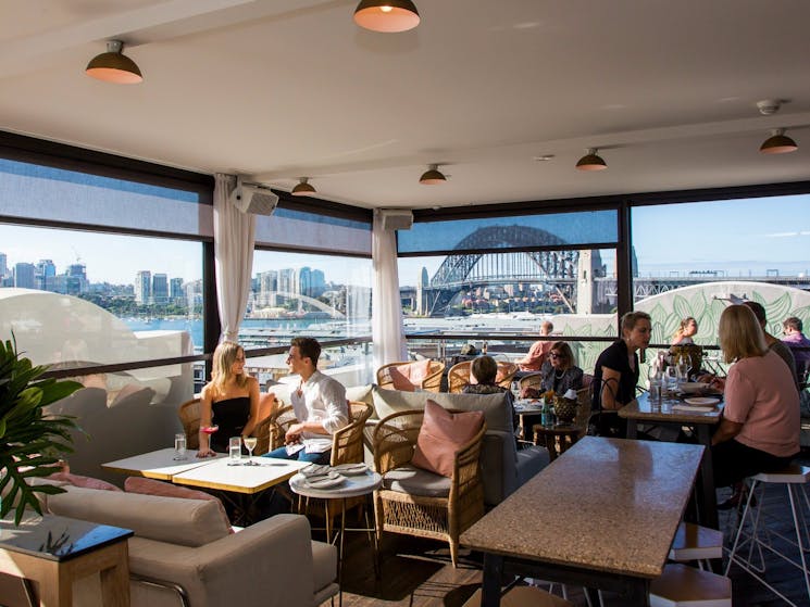 People enjoying food and drink at Henry Deane's rooftop cocktail lounge