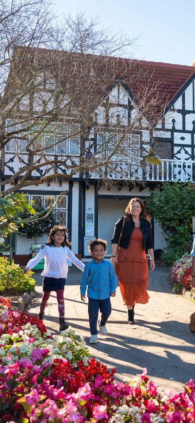 Family walks in front of a Tudor style architecture buidling