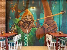 A Mural of Robin Hood A man in a cape with a bow and arrow