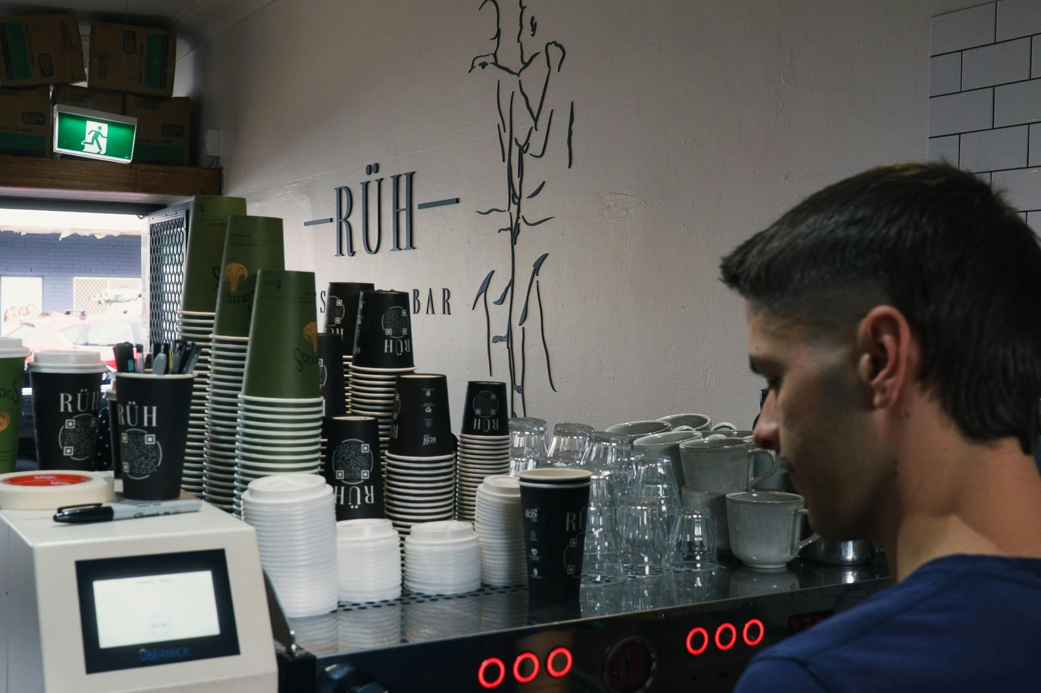 Staff member behind the coffee machine at RÜH Espresso Bar