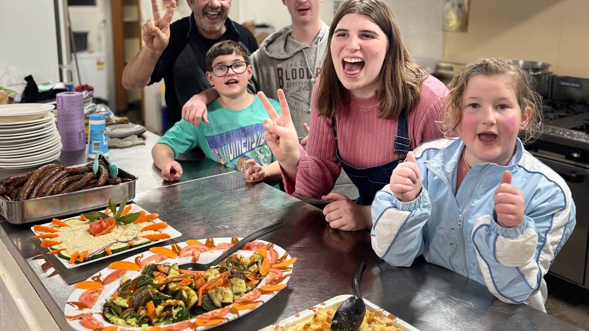 Participants with the camp chef in the kitchen after preparing healthy meals ready to enjoy together