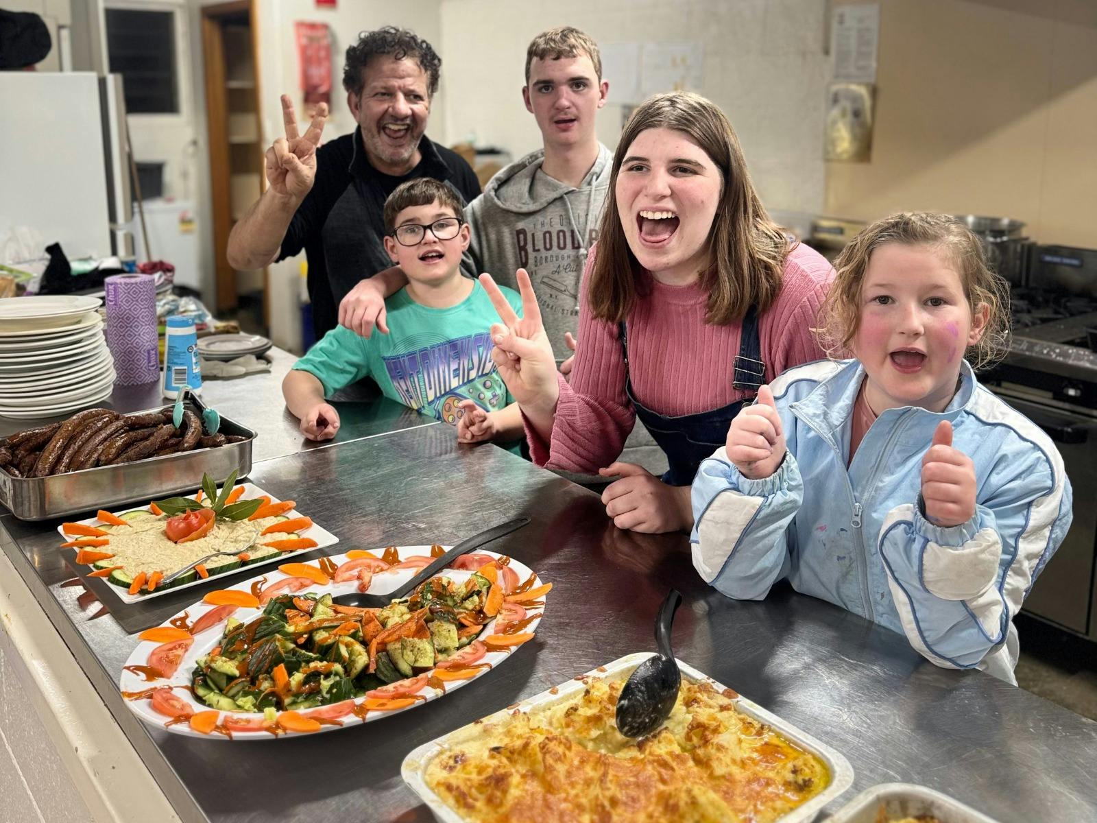 Participants with the camp chef in the kitchen after preparing healthy meals ready to enjoy together
