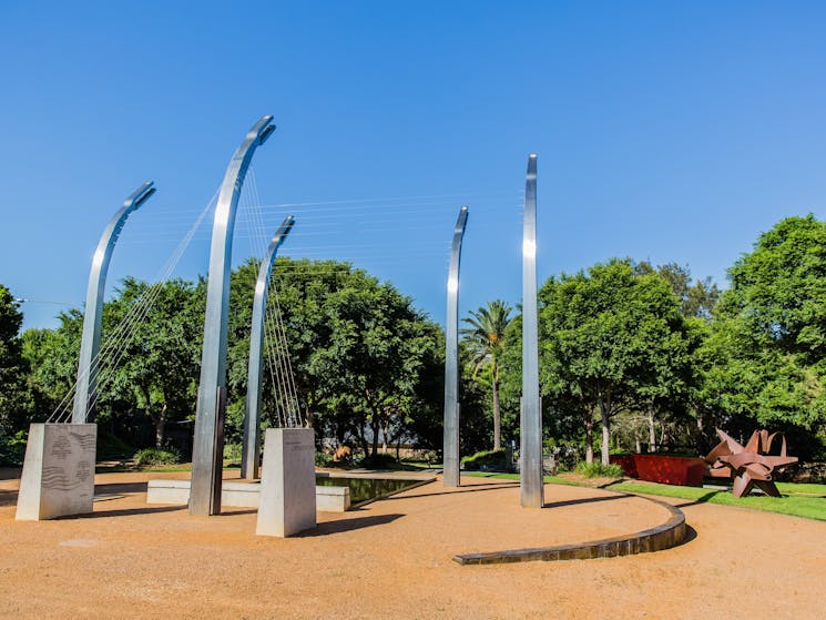 tall silver poles with wires connecting them to each other and concrete pylons