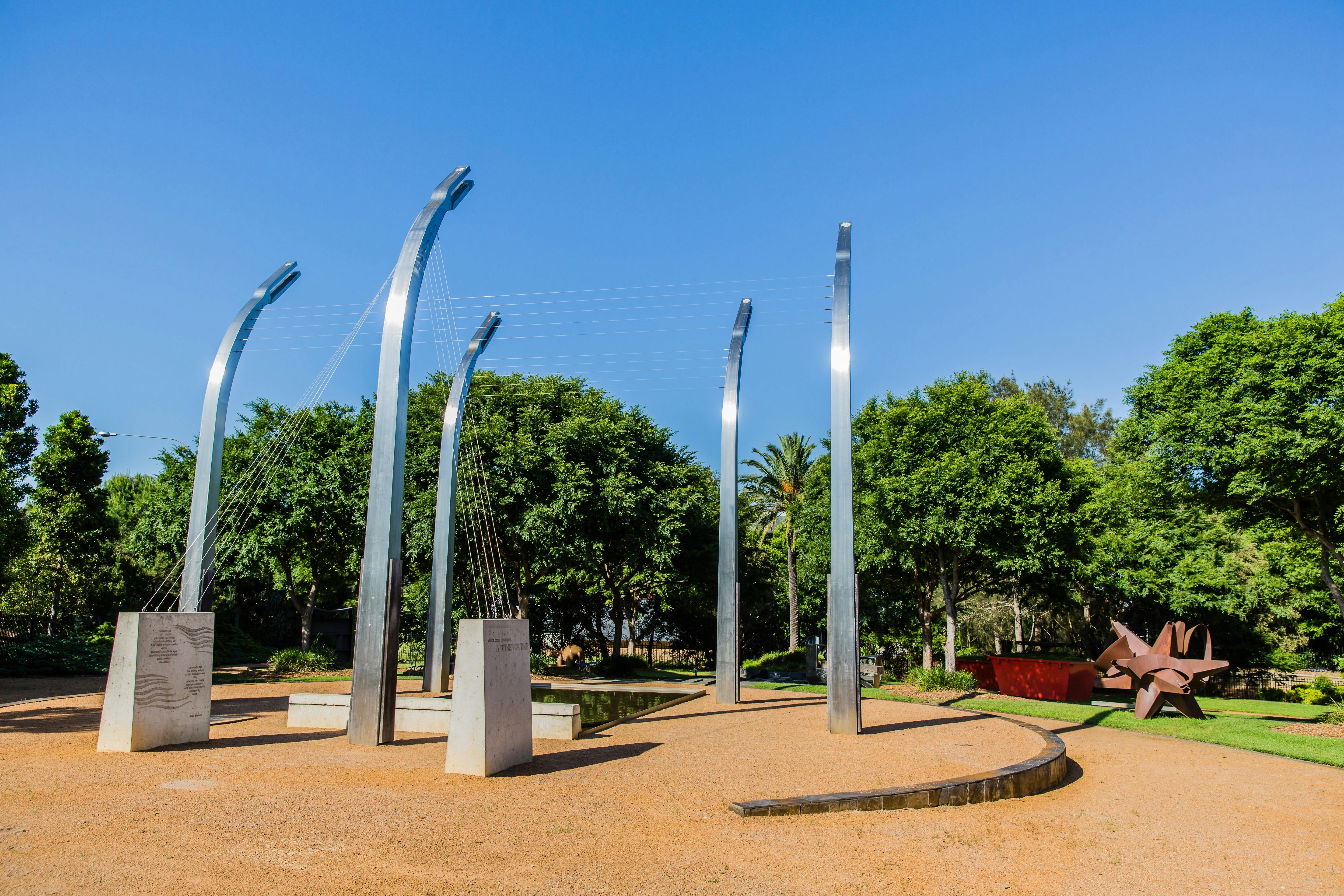 tall silver poles with wires connecting them to each other and concrete pylons