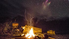 Campfire and camp at night.