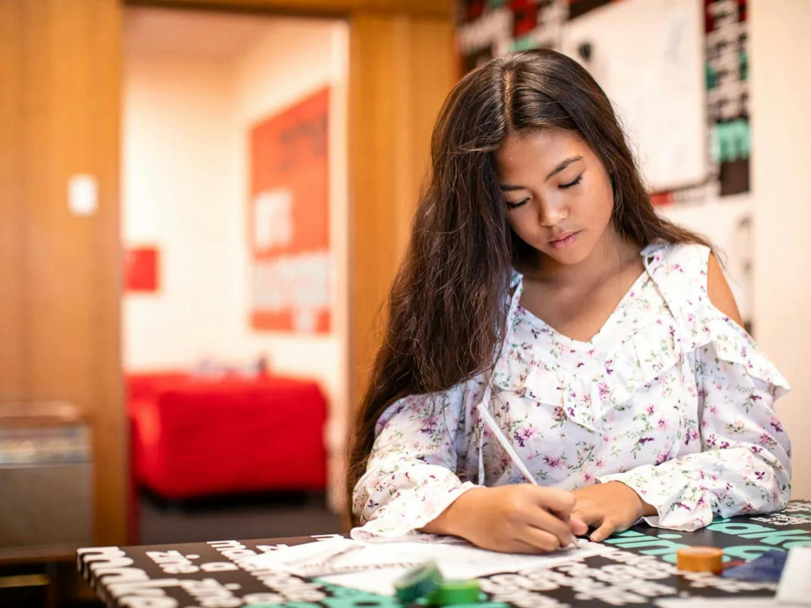 A girl sitting down and writing