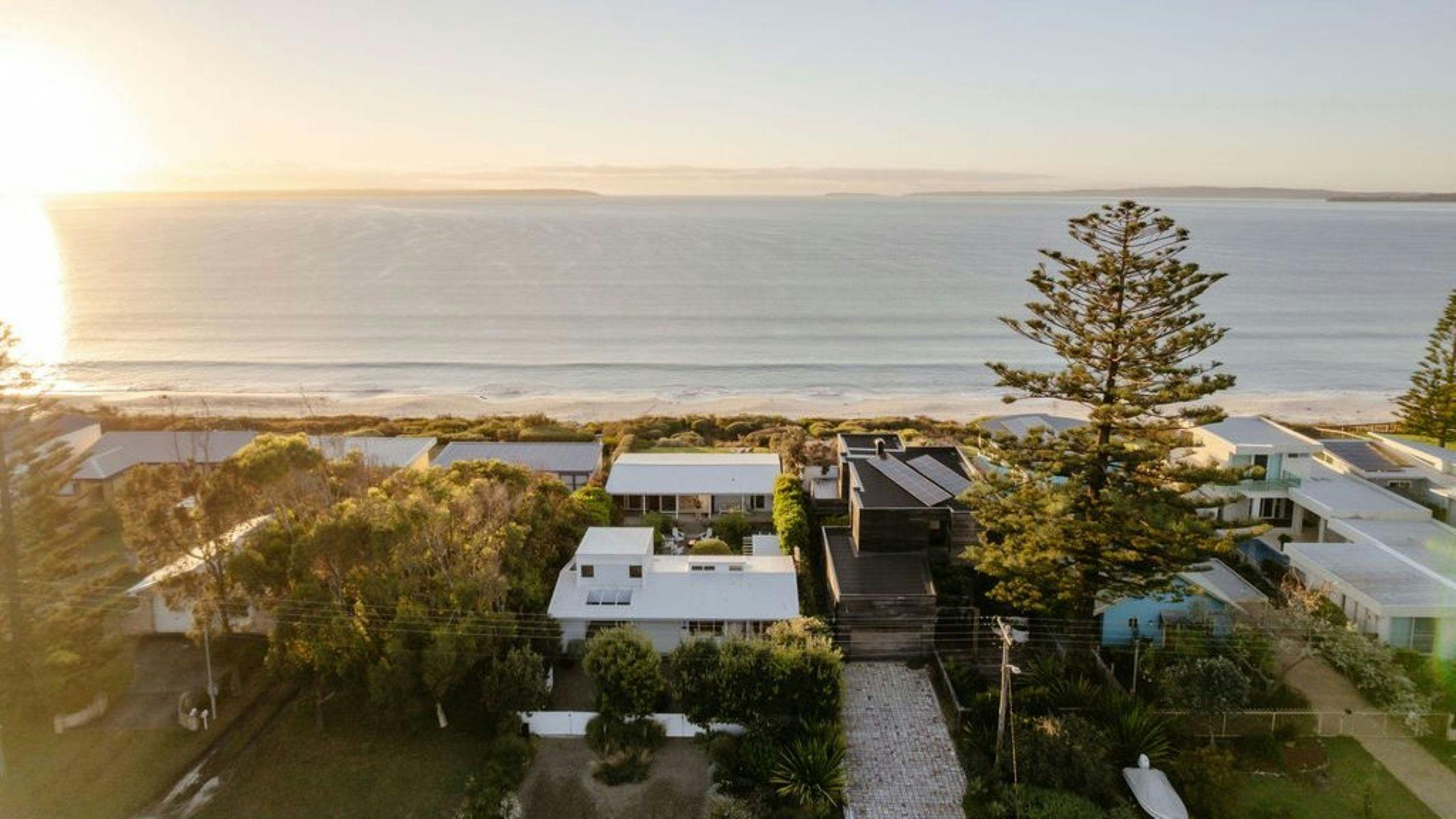 Aerial view of entire property, sun is rising and shows the rays falling on Kindred and the ocean