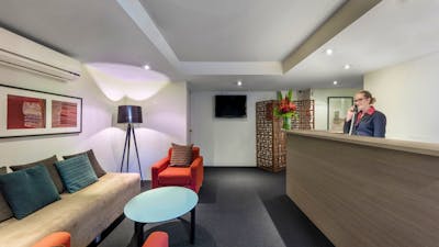 Reception with various furniture and woman at desk