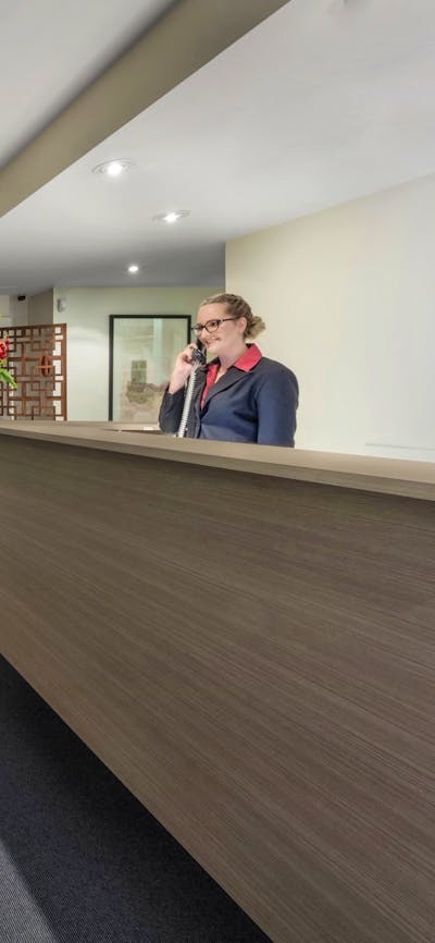 Reception with various furniture and woman at desk