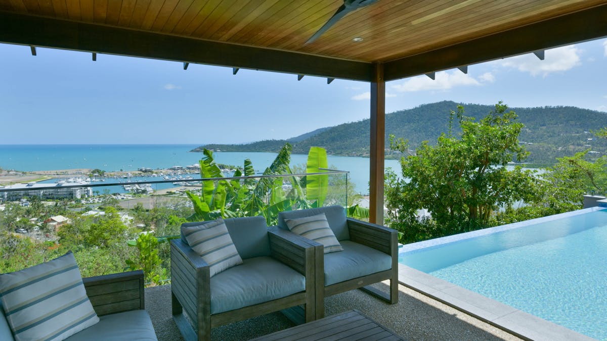 Cozy outdoor lounge area next to an infinity pool at Elementa Whitsundays