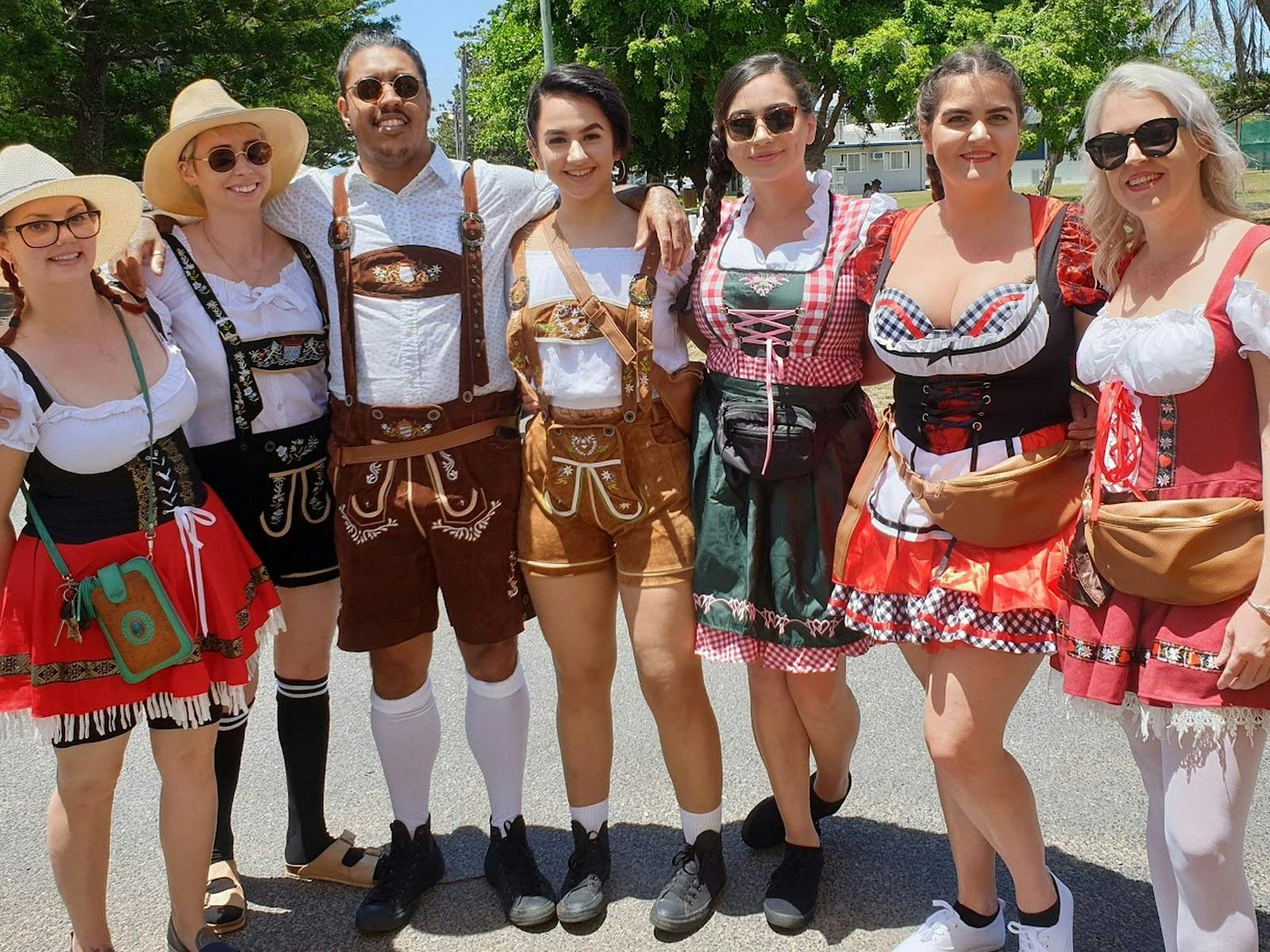 A group of seven dressed in traditional Bavarian costume.