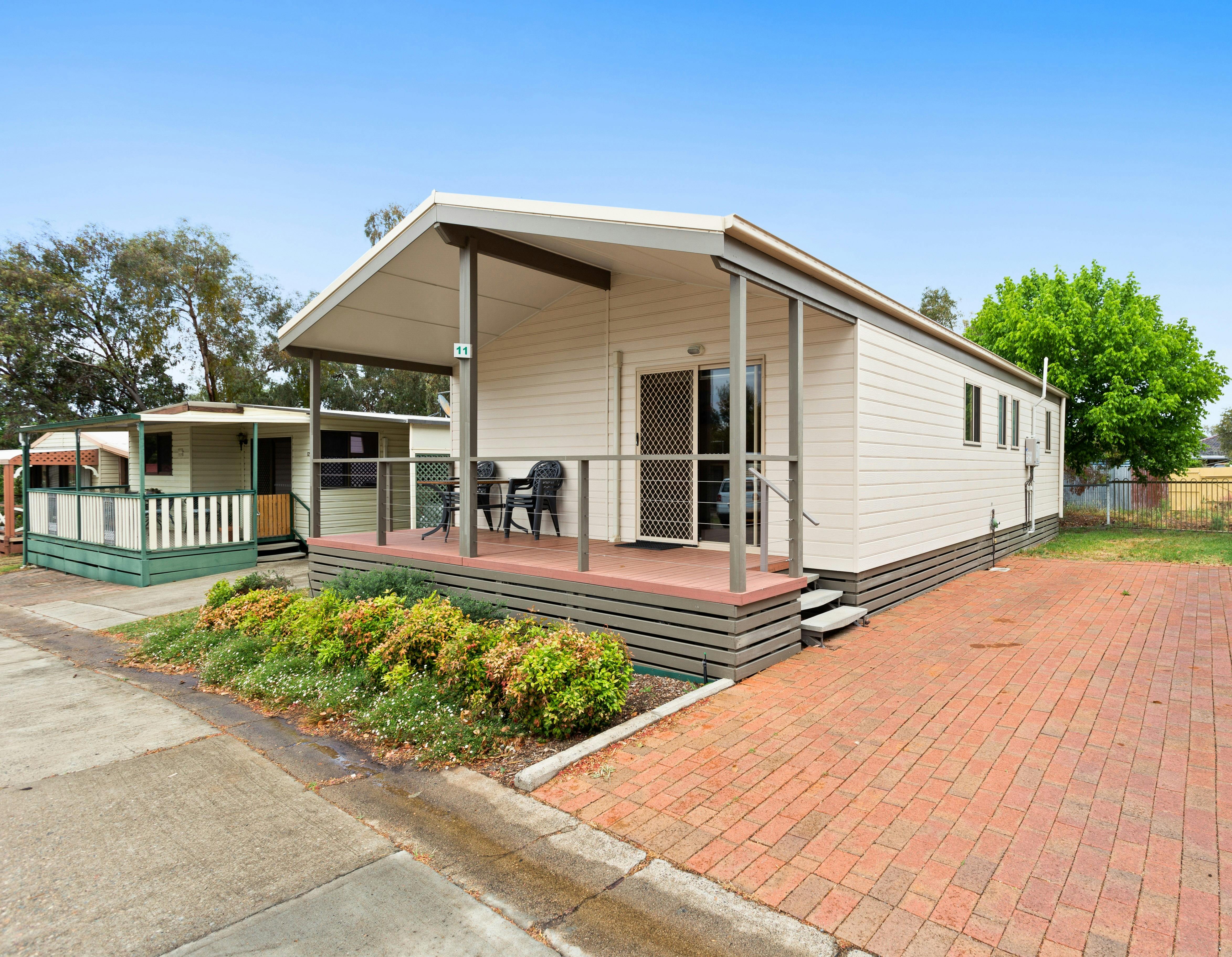 11번 캐빈 외부 정원 큰 차도 테이블과 의자가 있는 덮인 베란다.