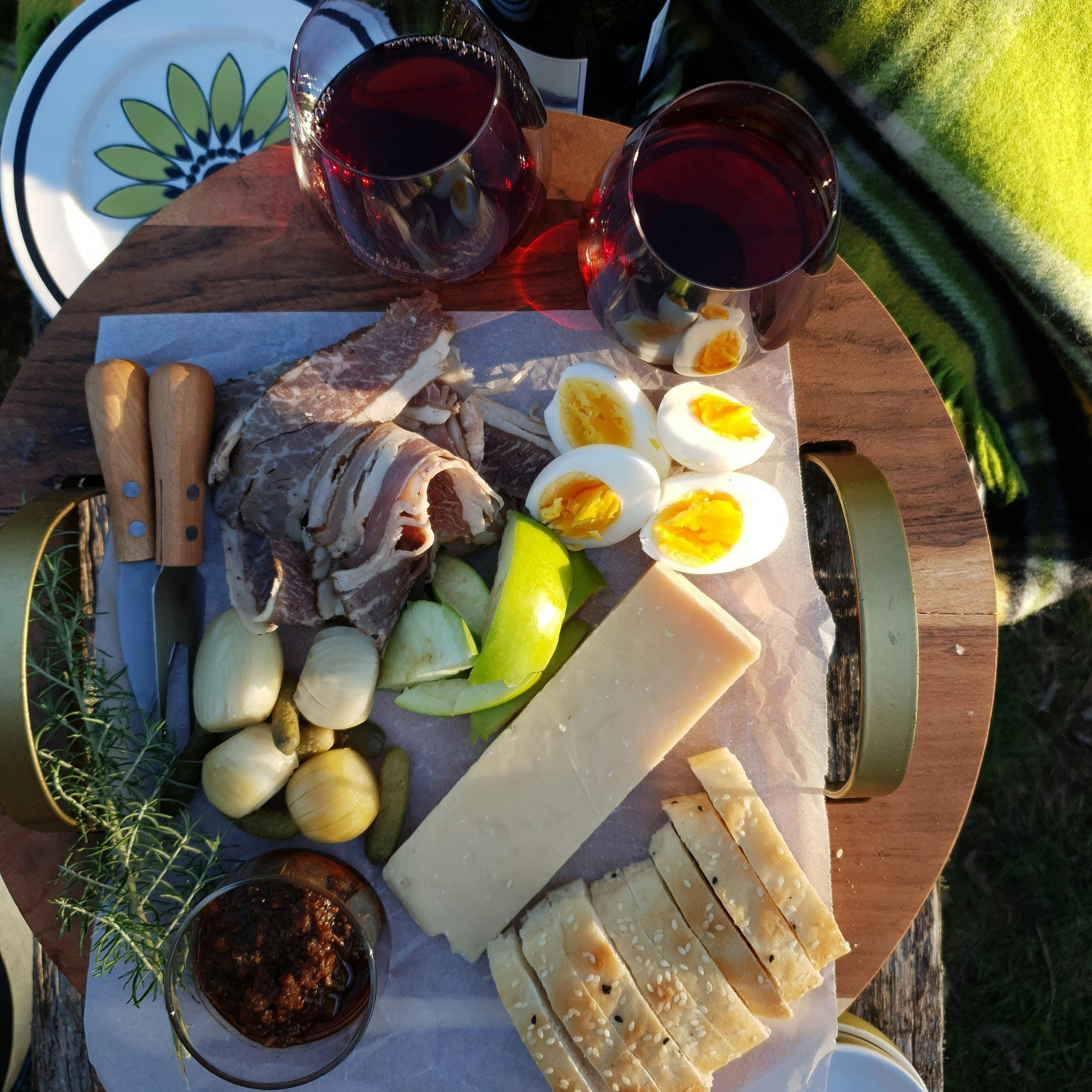 Ploughmans platter with glasses of pinot noir, vintage blankets and plates