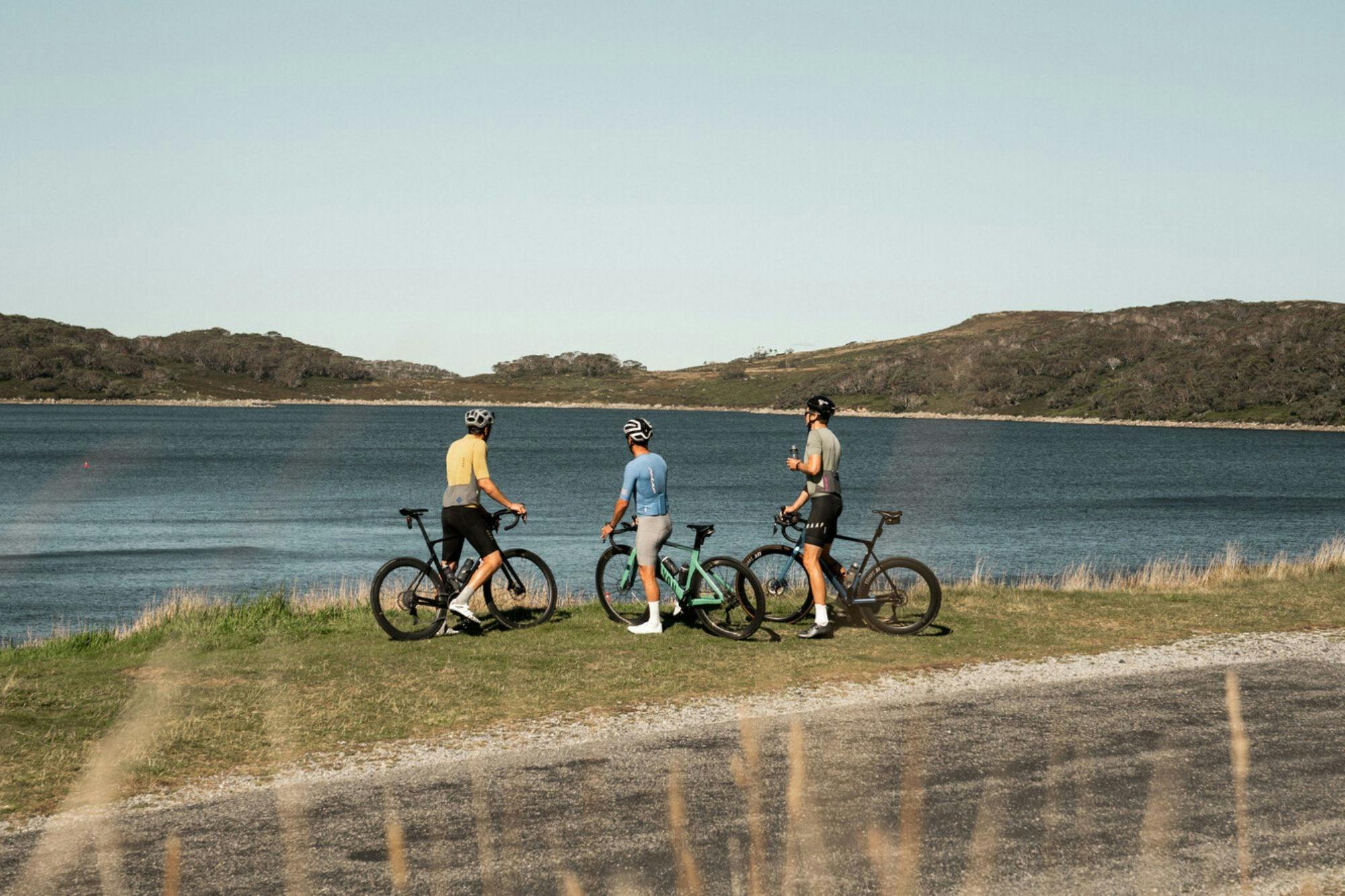 Three cyclists relaxing by Rocky Valley Lake after conquering the Falls Creek 7 Peaks Challenge