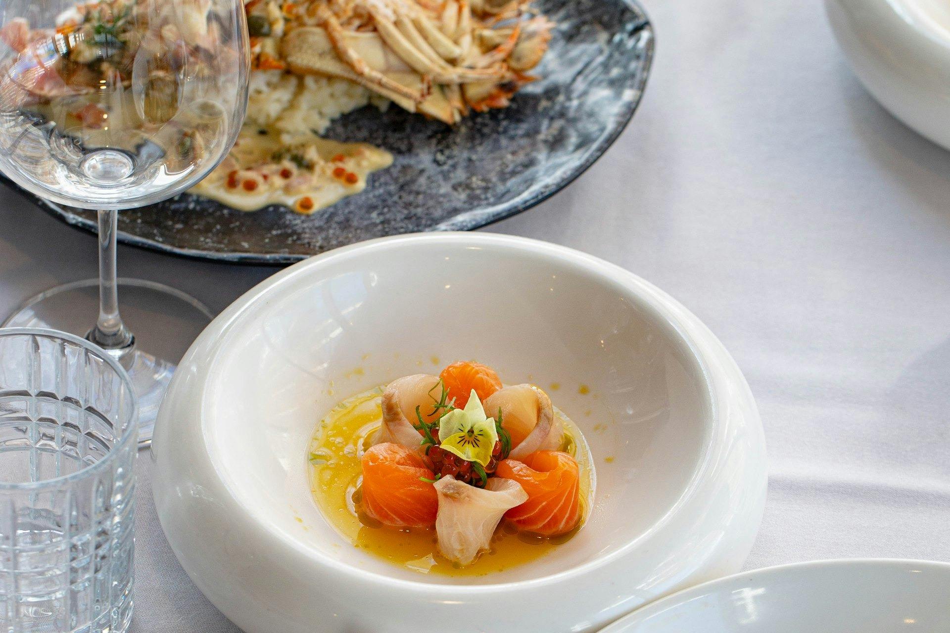 Shared dishes and crudo on the table at River House waterfront restaurant, Southport.
