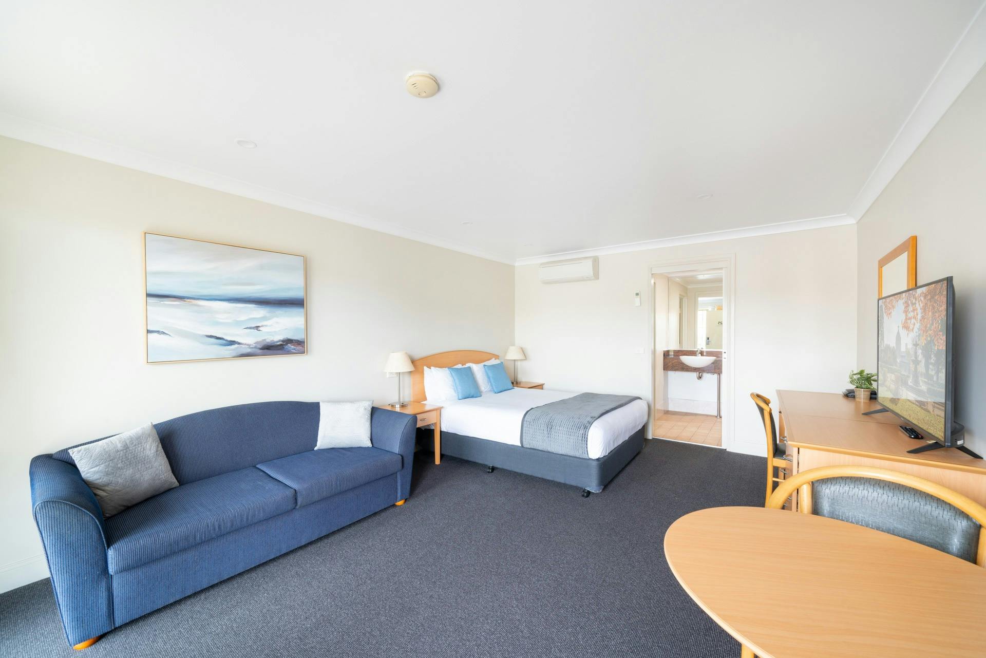 최고의 휴식을 위한 편안한 침대와 아늑한 라운지 공간을 갖춘 호텔 객실입니다.