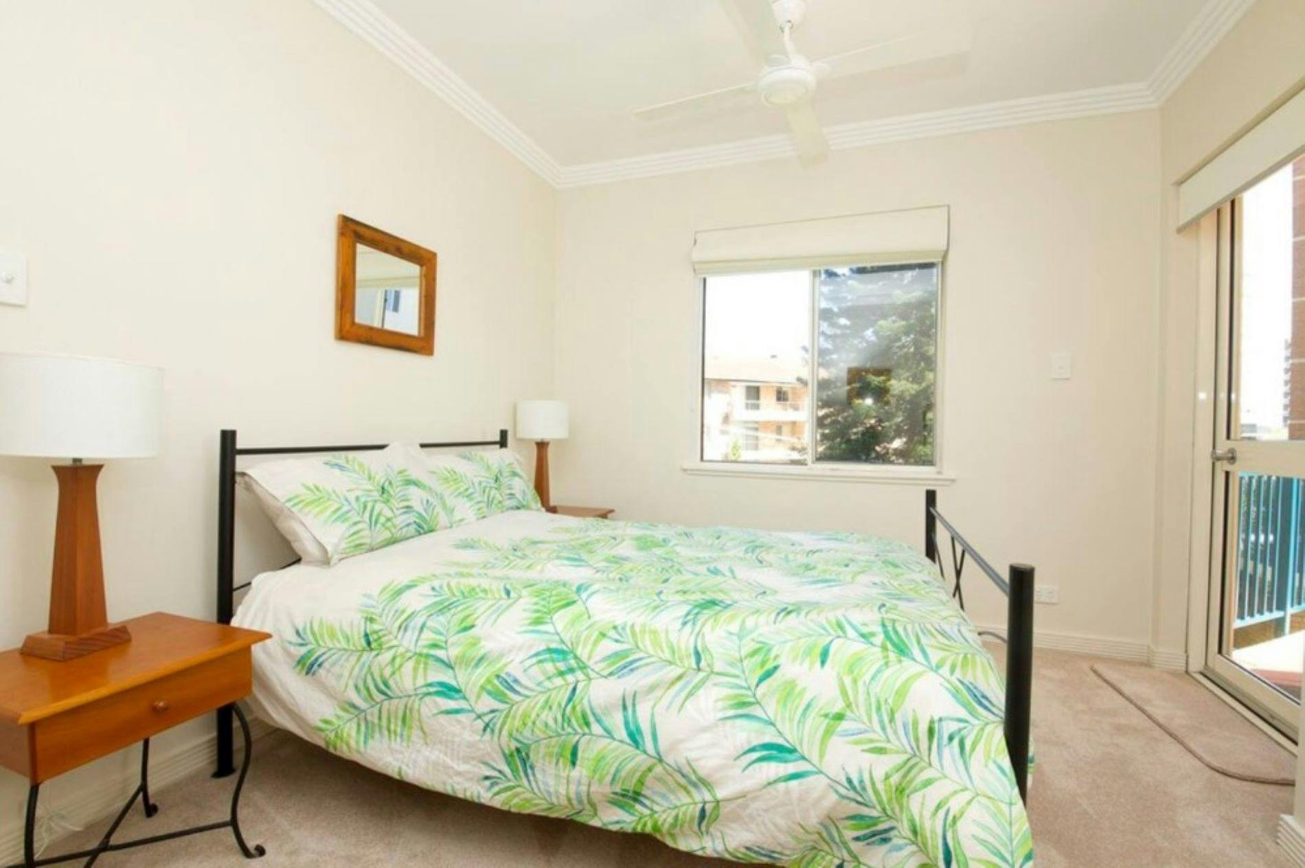 Master bedroom with ceiling fan and balcony access