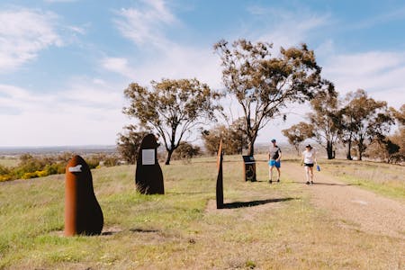two friends walking towards Wiradjuri art scultures