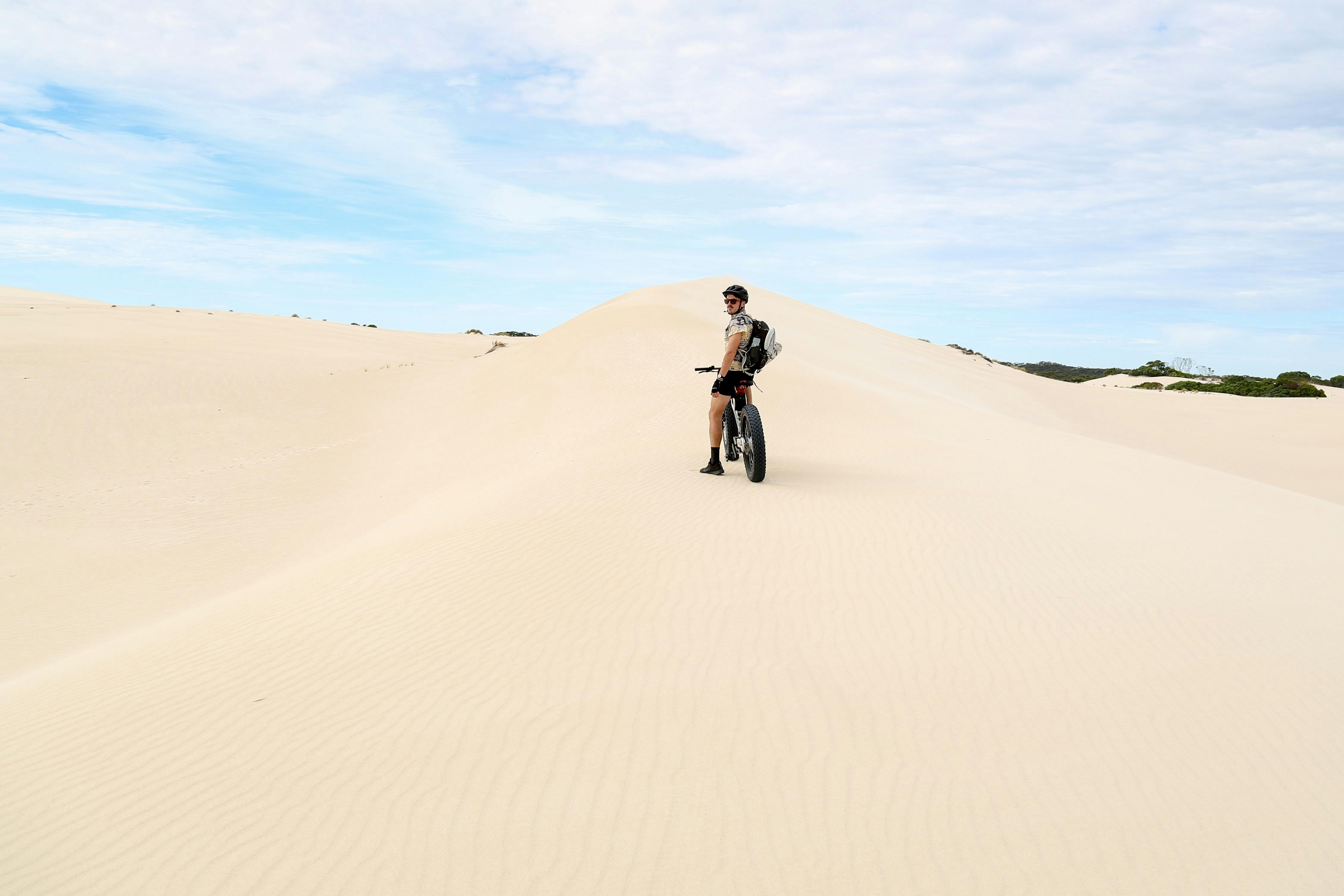 Man on bike alone on sand dune